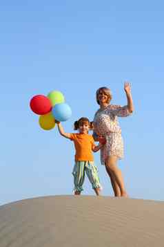 快乐妈妈。女儿气球海滩