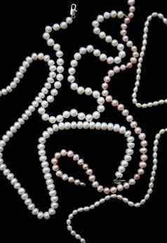 白色粉红色的珍珠项链黑色的丝绸