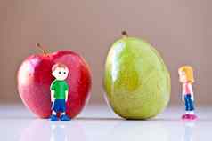 女孩男孩overshelmed健康的食物选择梨苹果