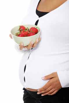 怀孕了女人持有沙拉碗草莓