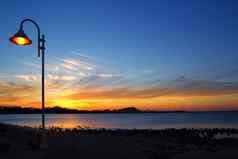 日落橙色蓝色的海景光路灯柱