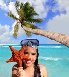 拉丁旅游女孩持有海星热带海滩