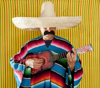 墨西哥男人。墨西哥披肩雨披帽子玩吉他