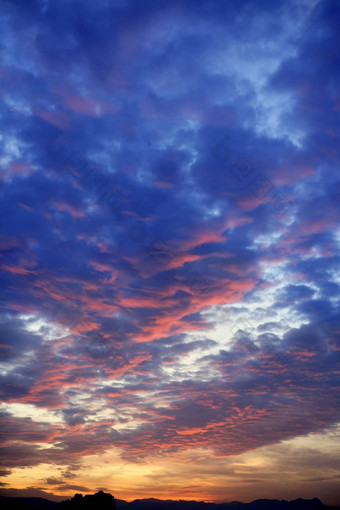 色彩斑斓的红色的蓝色的日落多云的天空