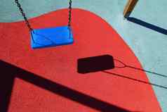 蓝色的公园摇摆不定的红色的地板上孩子们操场上