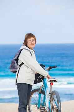 不错的高级夫人骑自行车海滩