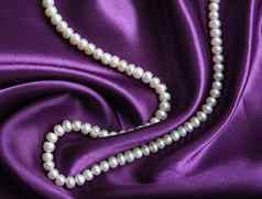 白色珍珠淡紫色丝绸背景