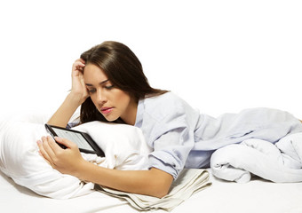 美丽的女人床上阅读电子书