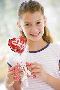 年轻的女孩情人节一天持有爱主题气球微笑