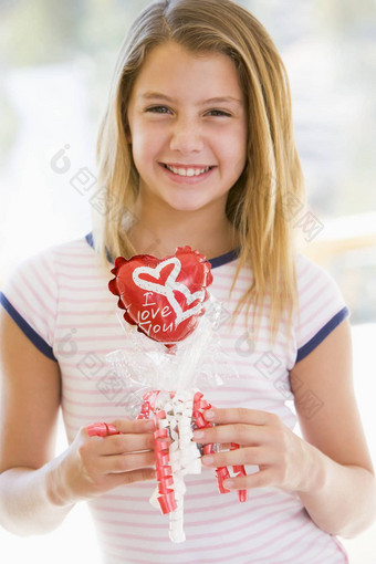 年轻的女孩情人节一天持有爱主题气球微笑