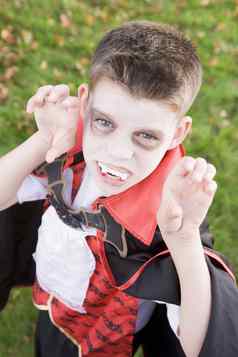 年轻的男孩在户外穿吸血鬼服装万圣节