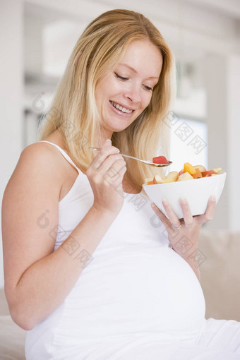 怀孕了女人碗水果沙拉微笑