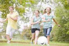 年轻的女孩朋友玩足球