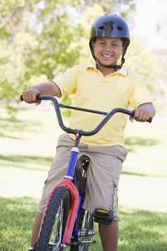 年轻的男孩自行车在户外微笑