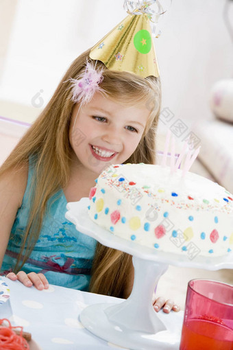 年轻的女孩穿聚会，派对他生日蛋糕微笑