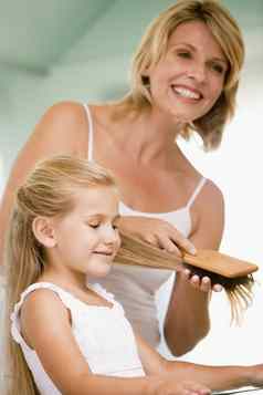 女人浴室刷牙年轻的女孩的头发