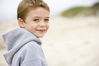 年轻的男孩站海滩微笑