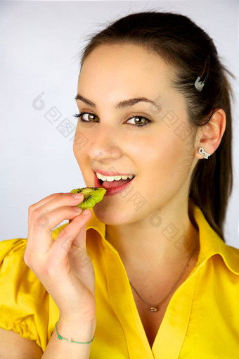 美丽的女孩吃新鲜的猕猴桃微笑快乐
