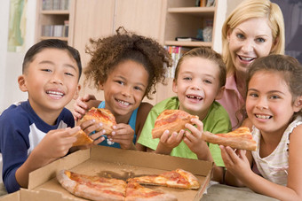 年轻的孩子们在室内女人吃披萨微笑