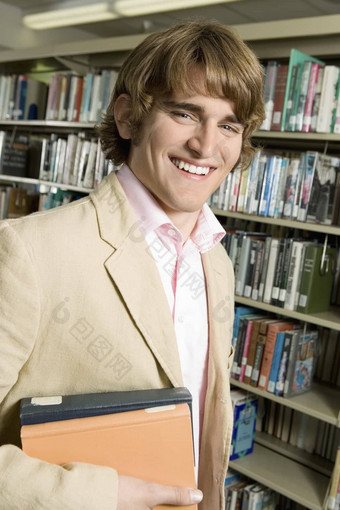 微笑年轻的男人。图书馆