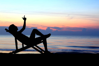 躺椅男人。海滩日落