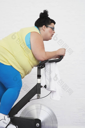 超重女人骑锻炼自行车