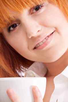 美丽的女人红色的头发杯茶