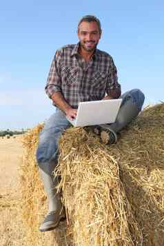 农民坐着稻草束电脑