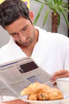 男人。阅读杂志早餐