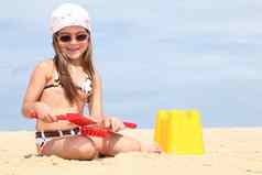 年轻的女孩使沙堡海滩
