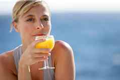 女人享受玻璃橙色汁海