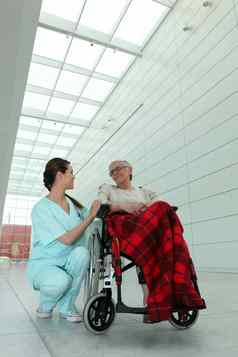 年轻的浅黑肤色的女人护士上了年纪的爵士轮椅子医院