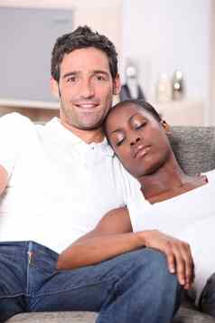年轻的夫妇白色男人。看黑色的女人睡觉