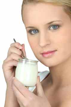 年轻的女人吃酸奶