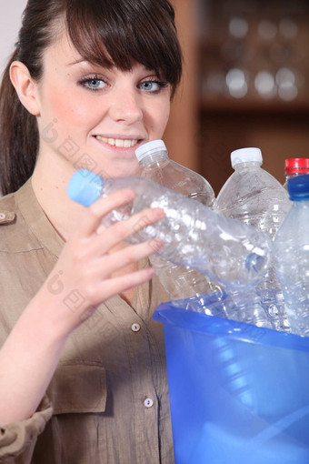年轻的女人排序塑料瓶