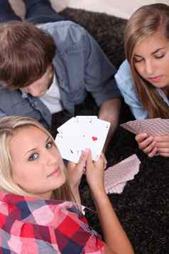 年轻的人玩卡片女孩显示赢得手