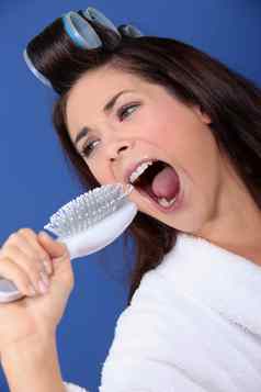 女人卷发器牙刷手唱歌