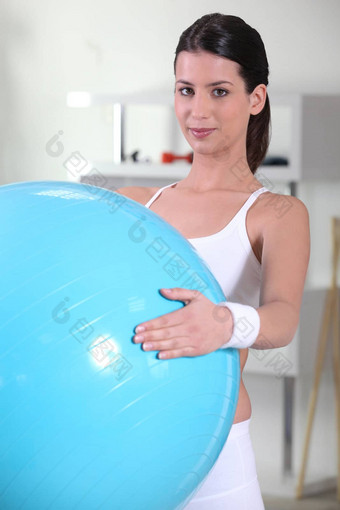 浅黑肤色的女人蓝色的球健身房保持