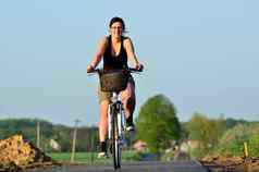 年轻的女人骑自行车路径