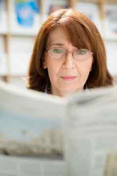 上了年纪的女人眼镜阅读报纸图书馆