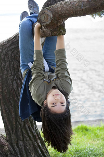 年轻的青少年女孩挂上行树肢体