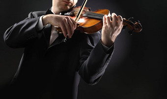 小提琴家音乐家玩小提琴黑暗背景