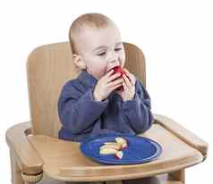 年轻的孩子吃桃子高椅子