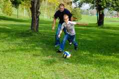 年轻的男孩玩足球父亲