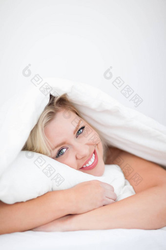 年轻的微笑女人拥抱枕头