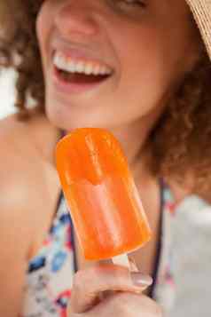 橙色冰棒举行微笑年轻的女人