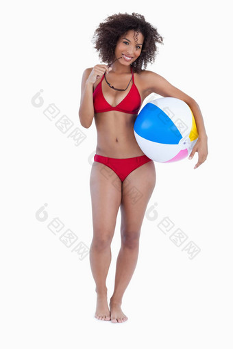 微笑女人持有海滩球太阳镜