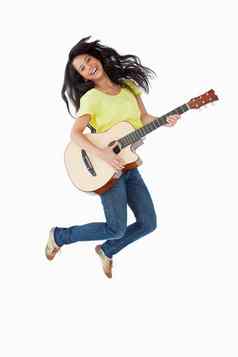 年轻的拉丁美洲人女人持有吉他跳