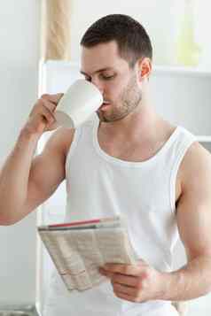 肖像年轻的男人。喝茶阅读新闻