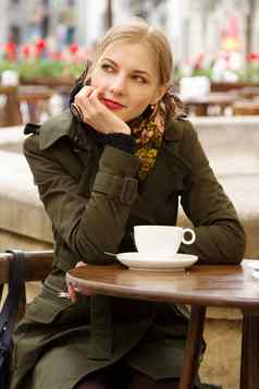 美丽的女人喝咖啡户外咖啡馆